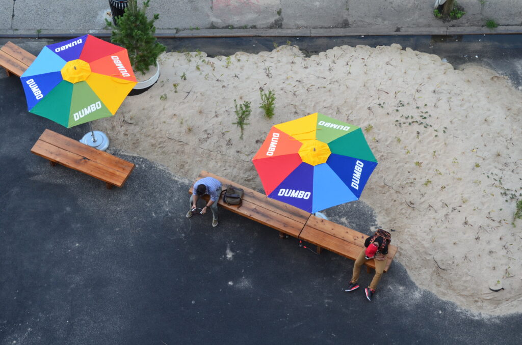 DUMBO Public Art Archive with colorful umbrellas and a couple of people sitting
