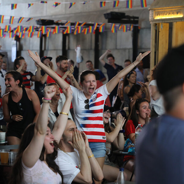 Woman cheering and holding her arms up while watching women's world cup