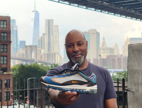 Sean Williams holding his sneaker celebrating his opening of his physical studio in DUMBO