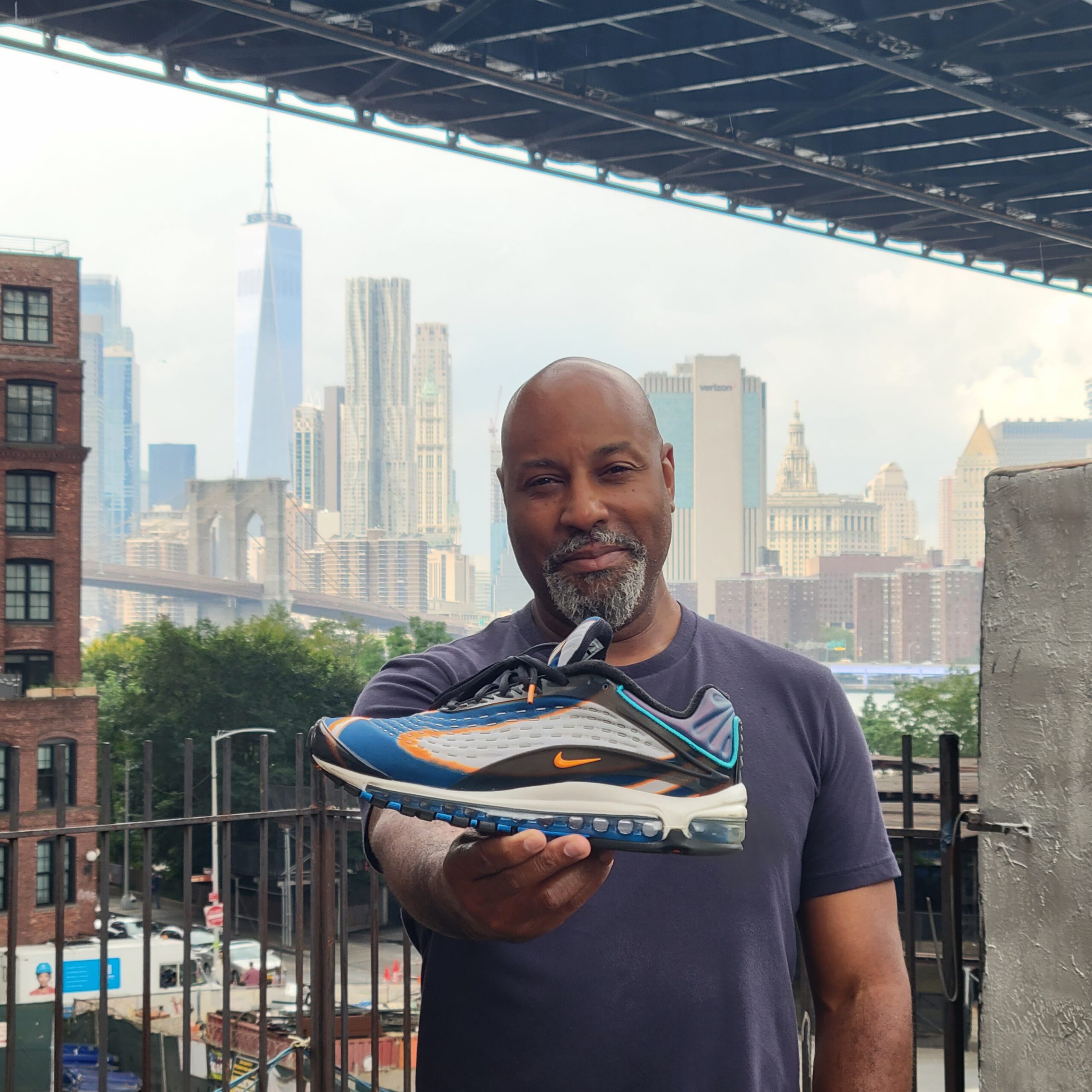 Sean Williams holding his sneaker celebrating his opening of his physical studio in DUMBO